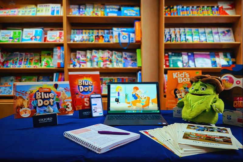 “ELT books for all ages displayed in a bookshop library with digital learning materials on a laptop”